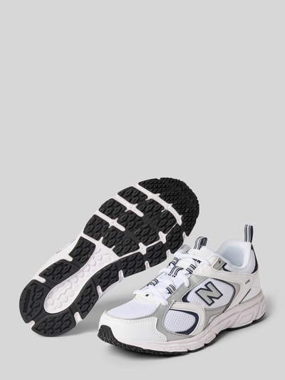 Produktfoto, Sneaker mit Logo-Detail Modell '408' von New Balance in Weiß mit schwarzen Elementen, abgerundete Passform, profilierte Sohle, passend für Damen, Absatzhöhe 3 cm, Schafthöhe 7 cm, Schaftweite 8 cm, texturierte Gummi-Sohle auf hellem Hintergrund.