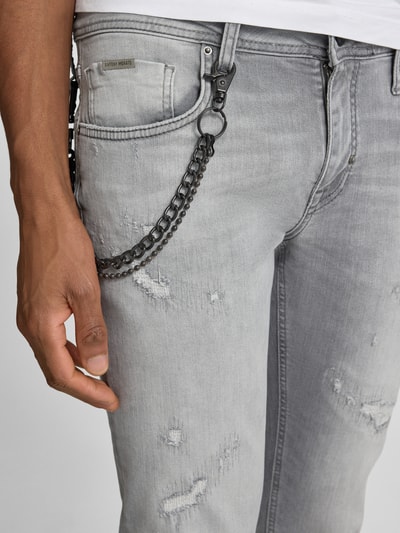 Männermodel trägt Tapered Fit Jeans mit Ketten-Detail von Antony Morato, grauer Baumwoll-Elasthan-Mix, Destroyed-Look, 5-Pocket-Design, Nahaufnahme Oberkörper