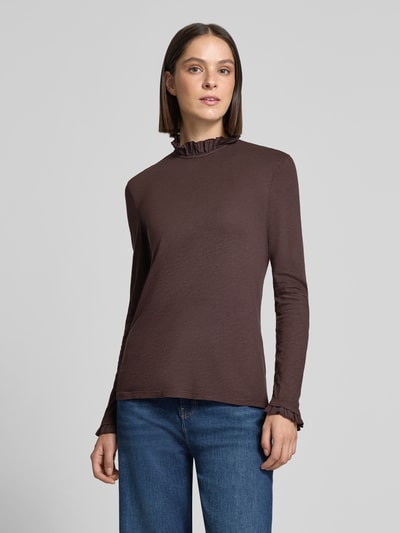 Frauenmodel trägt Longsleeve mit Rüschen von Rick & Royal aus brauner Baumwolle mit Stehkragen und geradem Schnitt, Nahaufnahme Oberkörper. Rückenlänge bei Größe S beträgt 63 cm.