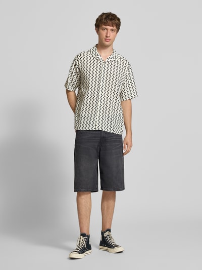 Männermodel trägt Regular Fit Freizeithemd mit Reverskragen Modell 'HOWIE' von Redefined Rebel, Allover-Look, Reine Baumwolle, Label-Detail, Schwarz-Weiß-Gemuster, Ganzkörperansicht von vorne, Rückenlänge 60 cm, Schulterbreite 60 cm, Ärmellänge 30 cm, Größe M.