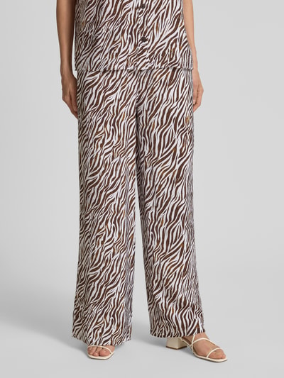 Frauenmodel trägt Stoffhose aus Viskose-Mix im Allover-Look Modell 'Mele' von FREE/QUENT, braun-weiß gemustert, Nahaufnahme Unterkörper. Damen Stoffhose, Wide Leg, Tunnelzug, Bundweite 39 cm, Innenbeinlänge 80 cm, Größe S.