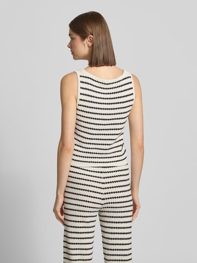 Frauenmodel trägt Strickweste mit V-Ausschnitt und Knopfleiste von REVIEW, schwarz-weiß gestreift, Material-Mix, Ganzkörperansicht Rückansicht.
