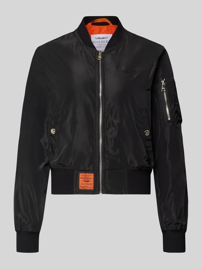 Productfoto, zwarte Bomberjacke mit Label-Patch und ritszak op de mouw van Original Bombers, oranje voering, losse fit, elastische boorden, steekzakken met drukknoop, staande kraag, context: dames bomberjack, lengte 53 cm, schouderbreedte 37 cm, borstwijdte 48 cm, mouwlengte 63 cm