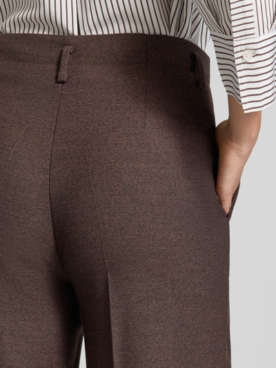 Frauenmodel trägt Bootcut Hose mit Bügelfalten von MORE & MORE, fein strukturiert, braun, Mix mit Viskose-Anteil, Nahaufnahme Rückansicht.