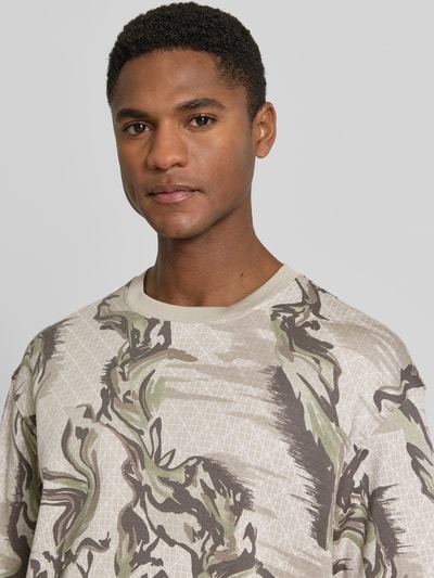 Mannenmodel draagt Regular Fit T-shirt uit puur katoen model 'TE-BARB' van BOSS Orange met all-over camouflagemotief, labelpatch, ronde hals, korte mouw, jersey materiaalverwerking, Nahaufnahme bovenlichaam.