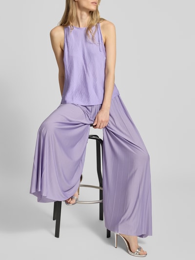 Frauenmodel trägt Wide Fit Stoffhose in Falten-Optik Modell 'Samantha' von GUIDO MARIA KRETSCHMER WOMAN in zartem Flieder, fließende Struktur, elastischer Bund, Bundweite 36 cm, Innenbeinlänge 75 cm, Ganzkörperansicht von vorne.