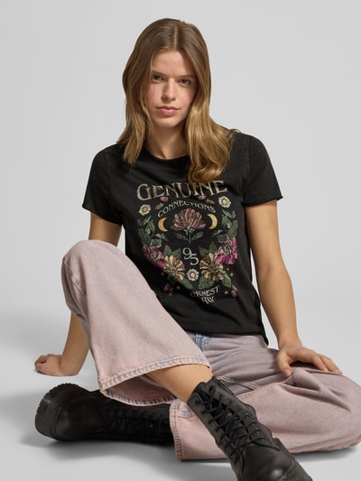 Kobiece model prezentuje Damski t-shirt Regular Fit T-Shirt aus reiner Baumwolle Modell 'LUCY' od ONLY, efekt: jednolity kolor, nadruk z motywem, okrągły dekolt, krótki rękaw, zakończenie rękawów i dół: zrolowany brzeg, dzianina dżersejowa, bawełna; pełny widok z przodu.