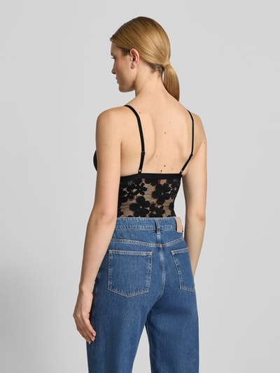 Frauenmodel trägt Wäsche-Body in Spitzen-Optik Modell 'BLOOM LACE BODYSUIT' von HUGO mit Label-Patch, Ganzkörperansicht Rückansicht.