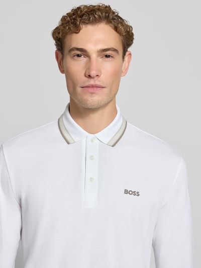 Männermodel trägt weißes Regular Fit Poloshirt aus reiner Baumwolle Modell 'Plisy' von BOSS, dezente Details, Nahaufnahme Oberkörper, Herren Poloshirt von BOSS.