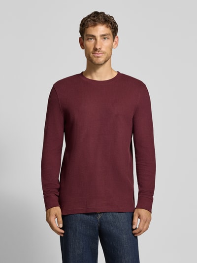Männermodel trägt Longsleeve mit Ripp-Struktur von MCNEAL in dunklem Rot, reine Baumwolle, gerader Schnitt, Ganzkörperansicht von vorne.