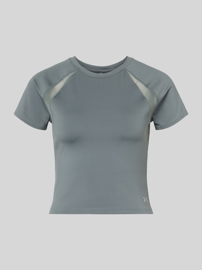 Frauenmodel trägt T-Shirt mit Mesh-Einsätzen und Logo von Under Armour, Material-Mix mit Stretch-Anteil, Cropped, Rundhalsausschnitt, Logo, Mesh-Einsätze, Rückenlänge bei Größe S 45 cm, Ganzkörperansicht von vorne.