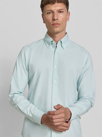 Männermodel trägt Regular Fit Freizeithemd aus reiner Baumwolle Modell 'RICKERT' von BOSS Orange, Optik: Unifarben, Nahaufnahme Oberkörper.