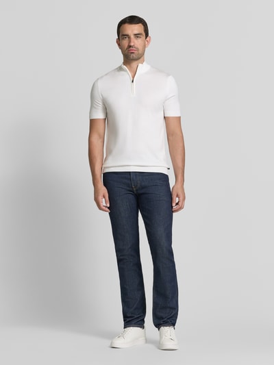 Męski model nosi Strickshirt aus Viskose-Mix mit Stehkragen Modell 'Vadin' von JOOP! COLLECTION, mieszanka wiskozy, dopasowany krój, stójka, krótki zamek błyskawiczny, długość tyłu 68 cm, długość rękawów 24 cm, białe, gładka tekstura, przód, pełna sylwetka