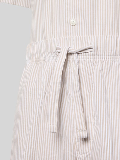 Männermodel trägt Regular Fit Pyjama aus reiner Baumwolle von Tommy Hilfiger mit Allover-Streifenmuster, Nahaufnahme Hüftbereich.
