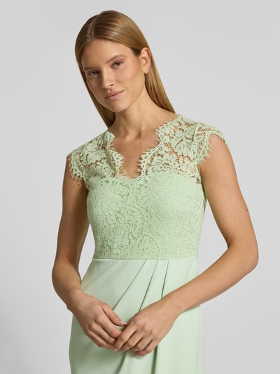 Frauenmodel trägt Midikleid mit Spitze Modell 'CLARA' von Vila in hellem Mintgrün, Mix aus glattem Stoff und floraler Spitze, taillierter Schnitt; Nahaufnahme Oberkörper.