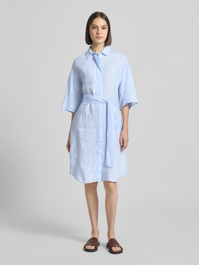 Kobiece model prezentuje Leinenkleid aus reinen Leinen Modell 'Derby' von 0039 Italy, len, taliowany krój, rękaw o dł. 1/2, wykładany kołnierz, listwa guzikowa, półprzezroczysty materiał, odpinana materiałowa tasiemka, długość tyłu w rozmiarze S: 96 cm, szerokość w rozmiarze S: 59 cm, długość rękawów w rozmiarze S: 24 cm, jasnoniebieski kolor, gładka faktura, całkowity widok z przodu