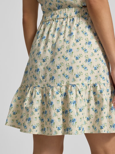 Frauenmodel trägt knielangen Damen Rock von MSCH Copenhagen aus Leinen-Mix mit Viskose-Anteil, floraler Allover-Print, elastischer Bund, Modell 'Solfried', Nahaufnahme Oberschenkel.