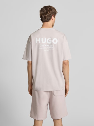 Männermodel trägt Loose Fit T-Shirt aus reiner Baumwolle Modell 'Nalono' von HUGO in Optik: Unifarben mit Label-Detail, Ganzkörperansicht Rückansicht.
