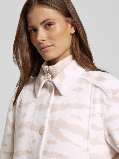 Kobiece model prezentuje Kurtka z mieszanki bawełny, krój regular fit, stójka, kołnierzyk koszulowy, listwa guzikowa, ukryty zamek błyskawiczny, wpuszczane kieszenie, detal z logo, długość tyłu 72 cm, szerokość ramion 50 cm, szerokość klatki piersiowej 55 cm, długość rękawów 59 cm, Jacke mit Stehkragen od Marc Cain, jasne beżowo-białe wzory, tekstura miękka, detaliczne ujęcie górnej części ciała.