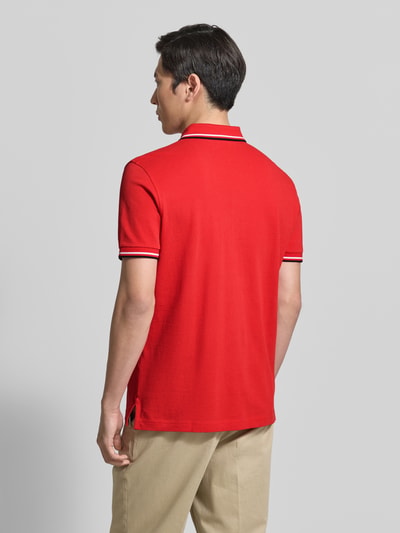Mężczyzna nosi Regular Fit Poloshirt mit Kontraststreifen von Christian Berg Men, czerwona bawełna, widok całej sylwetki od tyłu.