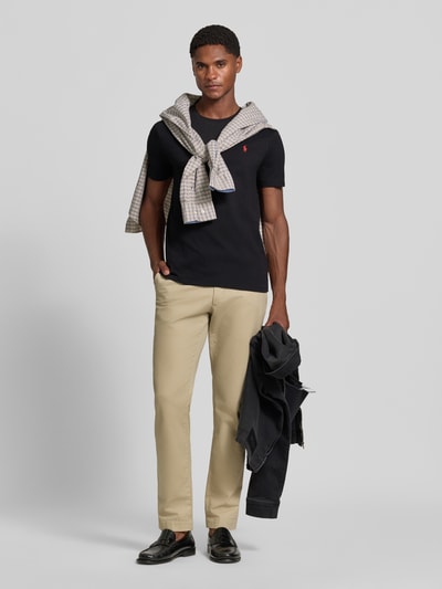Männermodel trägt Regular Fit T-Shirt-Set aus reiner Baumwolle von Polo Ralph Lauren in Schwarz, kombiniert mit heller Stoffhose, Ganzkörperansicht von vorne. Herren T-Shirt-Set von Polo Ralph Lauren.