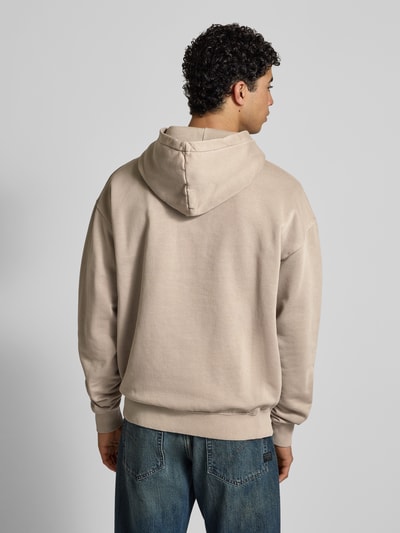 Männermodel trägt Oversized Hoodie mit Logo und Känguru-Tasche von Pegador aus Baumwoll-Mix in Beige, Herren, Ganzkörperansicht Rückansicht.