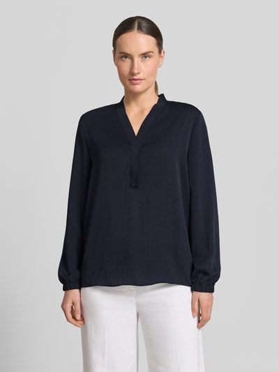 Frauenmodel trägt Bluse mit V-Ausschnitt und Label-Detail von Marc Cain, Loose-Fit, elastische Ärmelabschlüsse, Dunkelblau, Ganzkörperansicht von vorne, Damen Bluse, Rückenlänge bei Größe 36: 46 cm, Ärmellänge bei Größe 36: 60 cm.