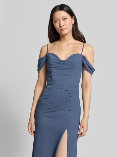 Modelka kobieca ma na sobie 'Abendkleid mit seitlichem Gehschlitz und Carmen-Ausschnitt' od Mascara, taliowany fason, długa sukienka, dekolt carmen, cienkie ramiączka, boczny rozporek, zapięcie na haftkę i zamek błyskawiczny, długość tyłu w rozmiarze 36: 156 cm, szerokość w rozmiarze 36: 40 cm, kolor niebieskoszary, gładka tekstura materiału, z przodu ujęcie do połowy ciała