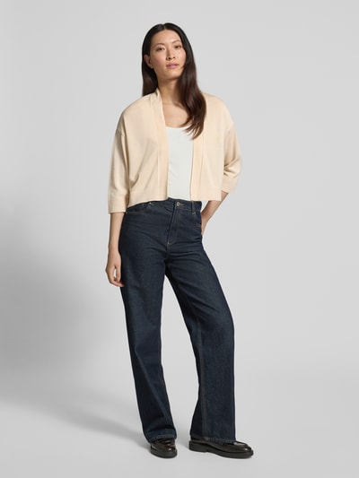 Frauenmodel trägt Strickjacke aus Lyocell-Baumwoll-Mix in offener Passform von Comma in Beige, Regular-Fit, 3/4-Arm, Ganzkörperansicht von vorne. Rückenlänge bei Größe S: 43 cm, Ärmellänge bei Größe S: 32 cm, Damen Strickjacke, schlichte Farben und weiche Textur.
