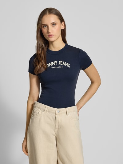 Vrouwenmodel draagt donkerblauw Slim Fit T-Shirt uit katoenmix Model 'SLIM VARSITY' van Tommy Jeans, unicolor, labelprint, ronde hals, korte mouw, Ganzkörperaanzicht van voren
