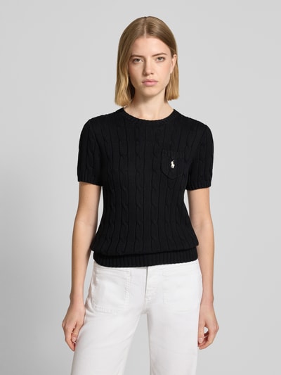 Frauenmodel trägt Regular Fit Strickpullover aus reiner Baumwolle von Polo Ralph Lauren, Optik: Unifarben, Logo-Stitching, Rundhals, Kurzarm, gerippter Ärmelabschluss, Brusttasche, Materialverarbeitung: Strick, Farbe: Schwarz, Textur: weiche Strickstruktur, Ganzkörperansicht von vorne.