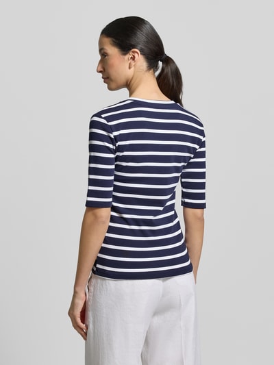 Modelka nosi T-shirt mit Streifenmuster und V-Ausschnitt od Christian Berg Woman, mieszanka bawełny i elastanu, krój regular fit, wzór w paski, dekolt w serek, długość tyłu w rozmiarze S: 55 cm, widok całej sylwetki z tyłu.