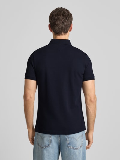Männermodel draagt Slim Fit Poloshirt met stretch-aandeel van Tommy Hilfiger, donkerblauw, korte mouwen, rugaanzicht, Ganzkörperansicht Rückansicht.