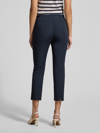 Frauenmodel trägt Schmale Schlupfhose aus Techno Cotton Superstretch von Raffaello Rossi, Slim-Fit, verkürzte Passform, Modell PENNY 6/8, dunkles Blau, glatte Oberfläche, Ganzkörperansicht Rückansicht.