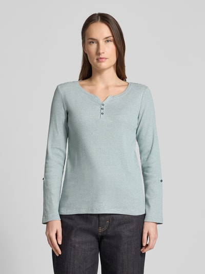 Vrouwenmodel draagt Regular Fit Langarmshirt aus Baumwoll-Mix van Tom Tailor, lichtblauw, effen two tone ribstructuur, label stitching, V-hals, lange mouwen, materiaal katoenmix. Vooraanzicht bovenlichaam.