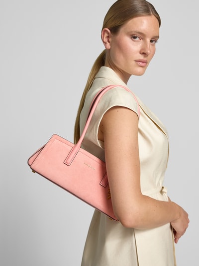 Frauenmodel trägt Handtasche aus Leder mit Label-Applikation Modell 'LAILA' von MICHAEL Michael Kors in Rosa, Reißverschluss, Nahaufnahme Oberkörper. Echtes Leder, Schulterriemen 56 cm, Maße 32x13x10 cm.