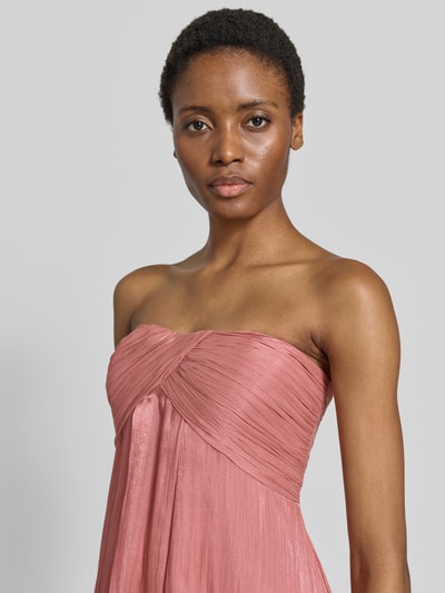 Frauenmodel trägt Empire Abendkleid in Glitzer-Optik von Jake*s Cocktail in Altrosa, plissierte Textur, Nahaufnahme Oberkörper.