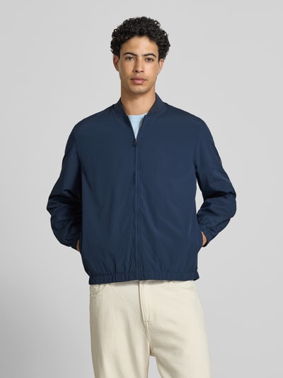Männermodel trägt Regular Fit Bomberjacke mit College-Kragen Modell 'BELVEDERE' von Pepe Jeans, Optik: Unifarben, Ganzkörperansicht von vorne. Passform: Regular-Fit, Kragenform: College-Kragen, Verschluss: Reißverschluss, Applikation: Label-Patch, Ärmelform: Langarm, Ärmelabschluss: Elastisch, Taschen: seitliche Eingrifftaschen.