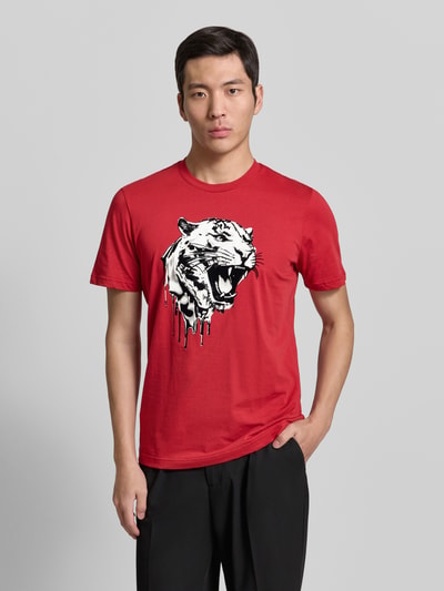 Männermodel trägt rotes T-Shirt mit Label-Detail von Antony Morato aus reiner Baumwolle, Regular Fit, mit Tigerprint, Ganzkörperansicht von vorne.