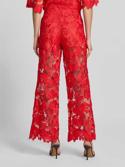 Kobiece modelka nosi Hose aus Spitze Modell 'GALA' od YAS w kolorze czerwonym, krój regular fit, elastyczny pas, szerokość w rozmiarze 36: 38 cm, długość nogawki od wewnątrz: 82 cm, koronkowa tekstura, widok całej sylwetki z tyłu