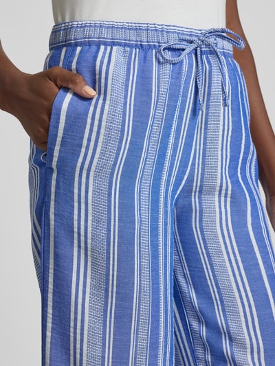 Frauenmodel trägt Culotte mit Kordelzug und Eingrifftaschen von Christian Berg Woman in Blau mit weißen Streifen, Loose-Fit, Nahaufnahme Oberkörper. Damenmode mit elastischem Bund, angedeuteten Gesäßleistentaschen, Bundweite 38 cm, Innenbeinlänge 60 cm bei Größe 36.