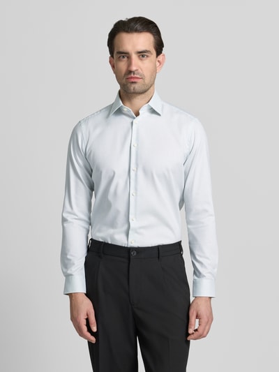 Męski model nosi Regular Fit Business Hemd aus Baumwolle mit Kentkragen von Christian Berg Men, biała bawełna, długi rękaw, krój regular fit, kent, długość pleców w rozmiarze 39/40: 78 cm, szerokość ramion w rozmiarze 39/40: 47 cm, długość rękawa w rozmiarze 39/40: 64 cm, widok całej sylwetki z przodu.