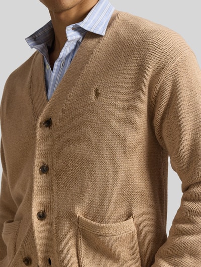 Mężczyzna nosi Regular Fit Strickjacke aus reiner Baumwolle od Polo Ralph Lauren, beżowy, gładki, dzianina, logo, kieszenie, krój regular fit. Nahaufnahme górnej części ciała.