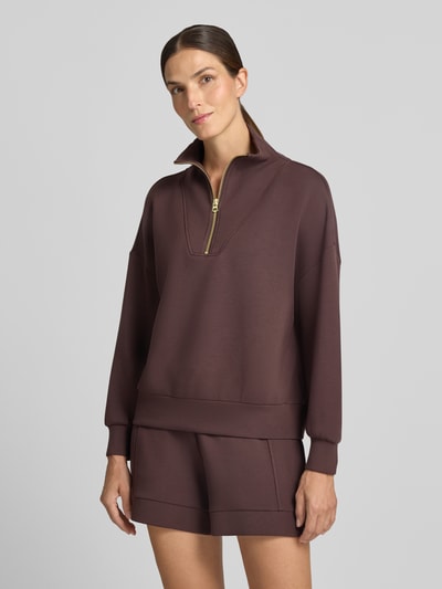 Frauenmodel trägt Regular Fit Sweatshirt aus Viskose-Mix Modell 'Hawley' von VARLEY in Dunkelbraun, Troyer-Kragen, Nahaufnahme Oberkörper.