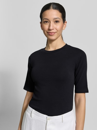 Frauenmodel trägt Slim Fit T-Shirt im Halbarm-Design von Christian Berg Woman, schwarzer Baumwoll-Mix, Rundhalsausschnitt, Nahaufnahme Oberkörper.