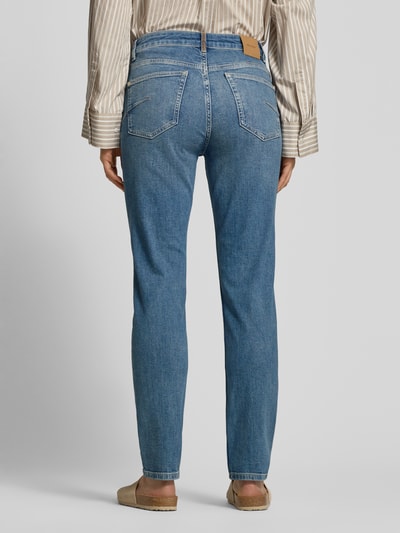 Vrouwenmodel draagt Slim Fit Jeans met steekzakken model 'Asya Jentra' van MOS MOSH in used-look, blauwe denim, full body achteraanzicht.
