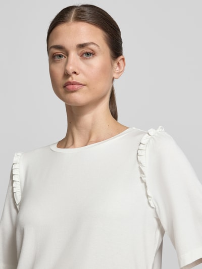 Frauenmodel trägt Regular Fit T-Shirt aus Viskose-Mix mit Rüschenbesatz von More & More in Weiß, Rundhalsausschnitt, elastischer Viskose-Mix, Damen T-Shirt, Nahaufnahme Oberkörper.