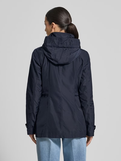 Frauenmodel trägt Regular Fit Jacke mit Logo-Print von Fuchs Schmitt, dunkelblau, Kapuze, Stehkragen, glatte Textur, Ganzkörperansicht Rückansicht.