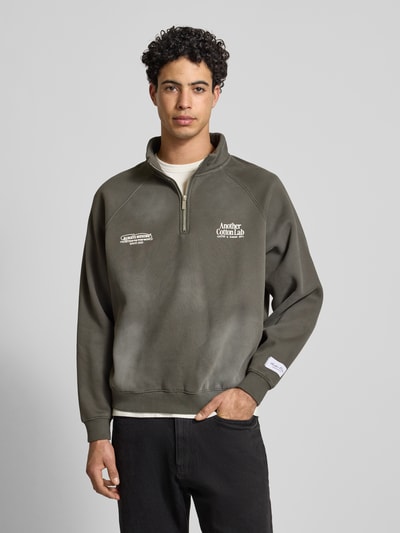 Männermodel trägt Sweatshirt mit Stehkragen von ANOTHER COTTON LAB, Baumwoll-Mix, Lockerer-Schnitt, olivgrün, Label-Details, Nahaufnahme Oberkörper.