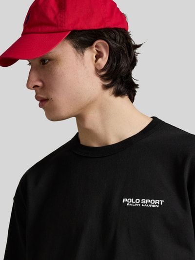 Mannelijk model draagt Regular Fit T-Shirt aus reiner Baumwolle van Polo Ralph Lauren, zwart, labelprint, korte mouwen, ronde hals, detailopname bovenlichaam.